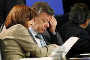 Colombia's President Santos wipes his face while talking with his Foreign Minister Holguin during the summit of the UNASUR in Lima