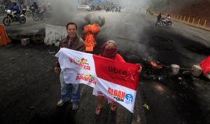 Supporters of Nasralla stand at a barricade settled to block road during a protest caused by the delayed vote count for the presidential election in Tegucigalpa